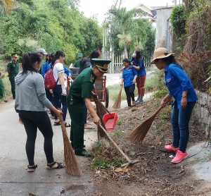 Các đoàn viên, thanh niên tham gia làm vệ sinh, tẩy xóa quảng cáo và cắm cờ Tổ quốc.