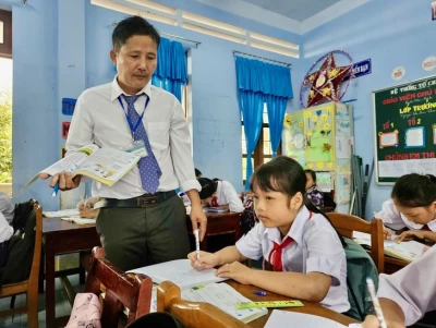 Thầy giáo Trần Văn Mênh luôn quan tâm các học sinh khó khăn - Ảnh: MINH CHIẾN
